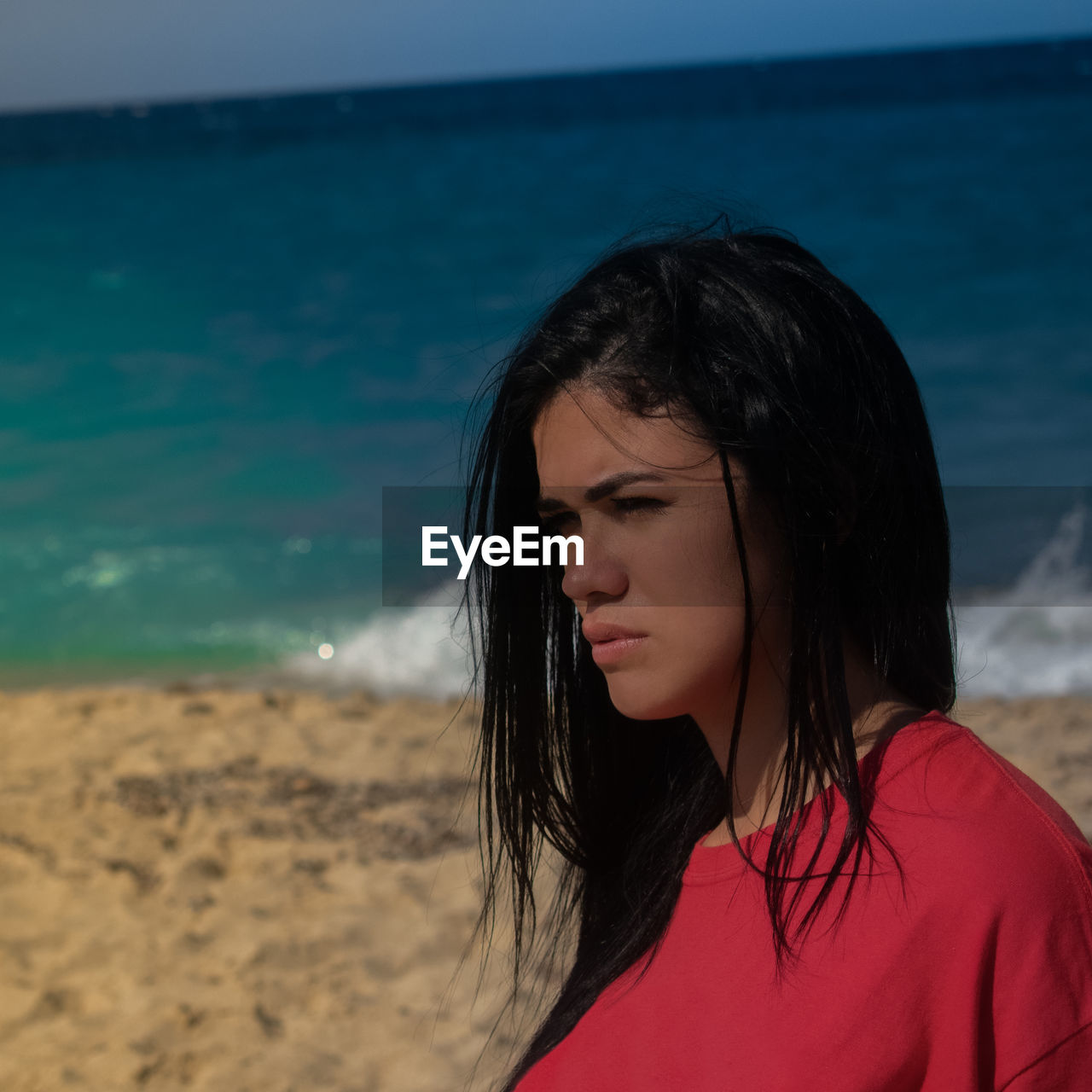 Portrait of woman at beach against sky