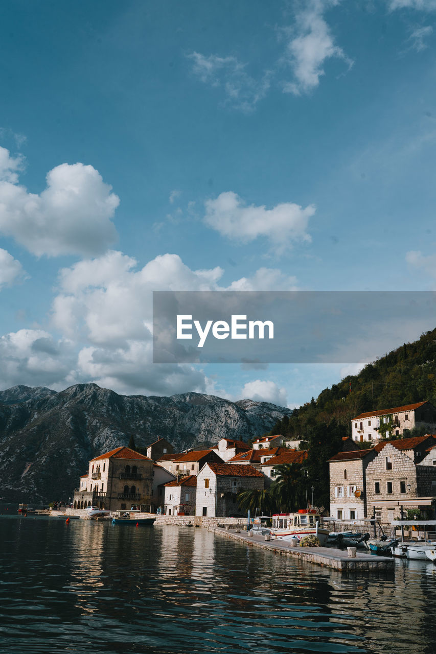 buildings by river against sky