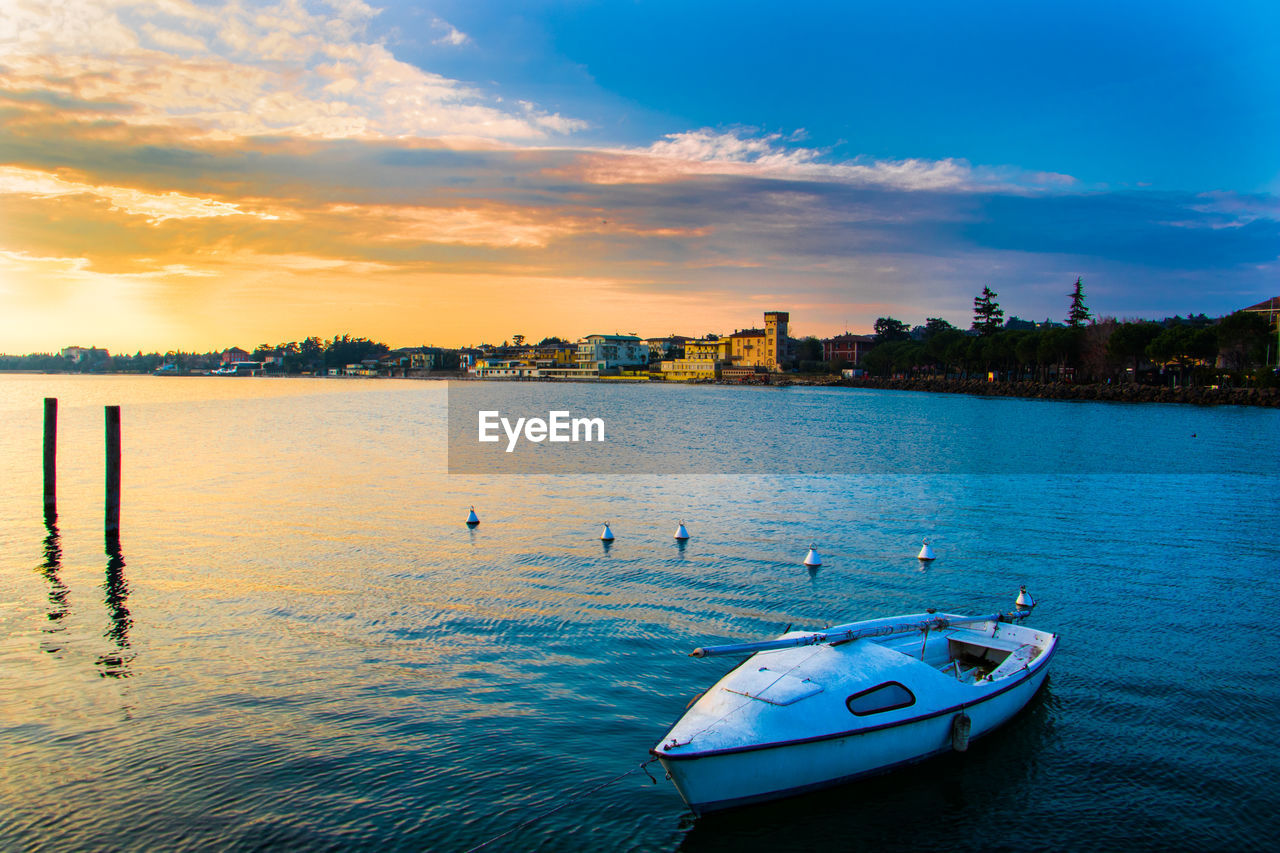 Boats in sea at sunset