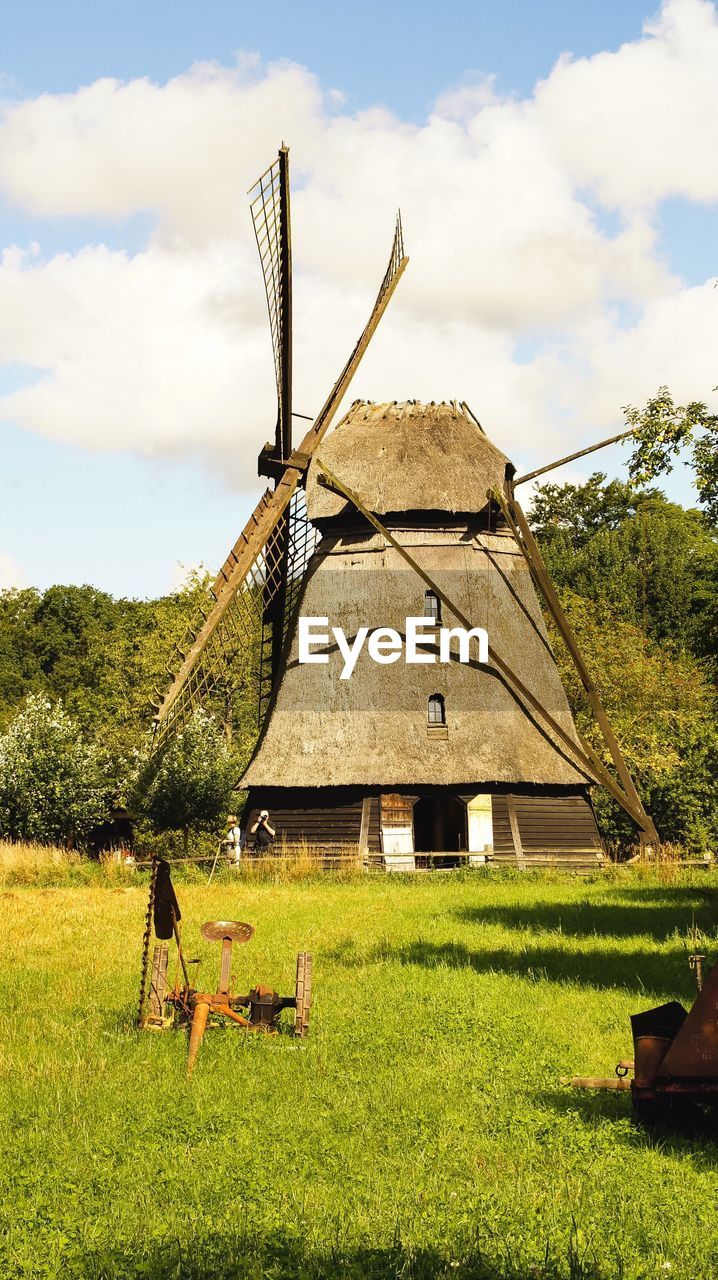 Traditional windmill on field against sky