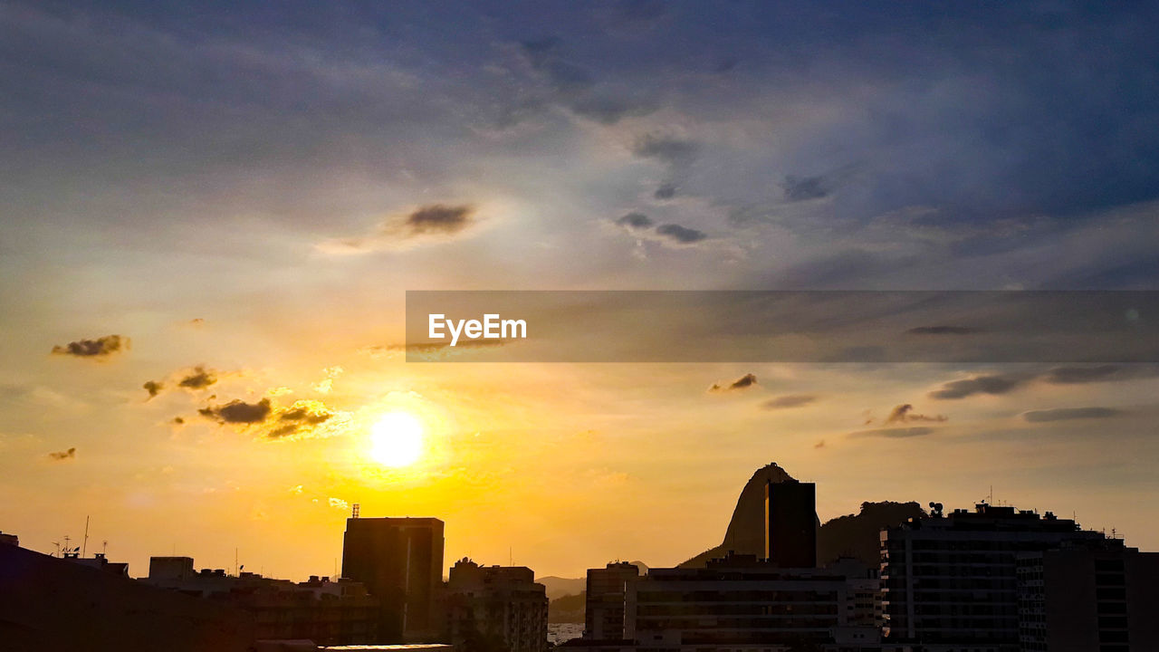 SILHOUETTE BUILDINGS AGAINST ORANGE SKY