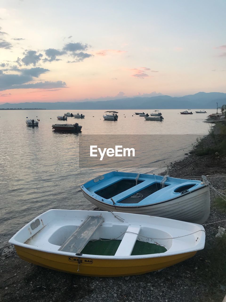 BOAT MOORED ON SEA AGAINST SKY DURING SUNSET