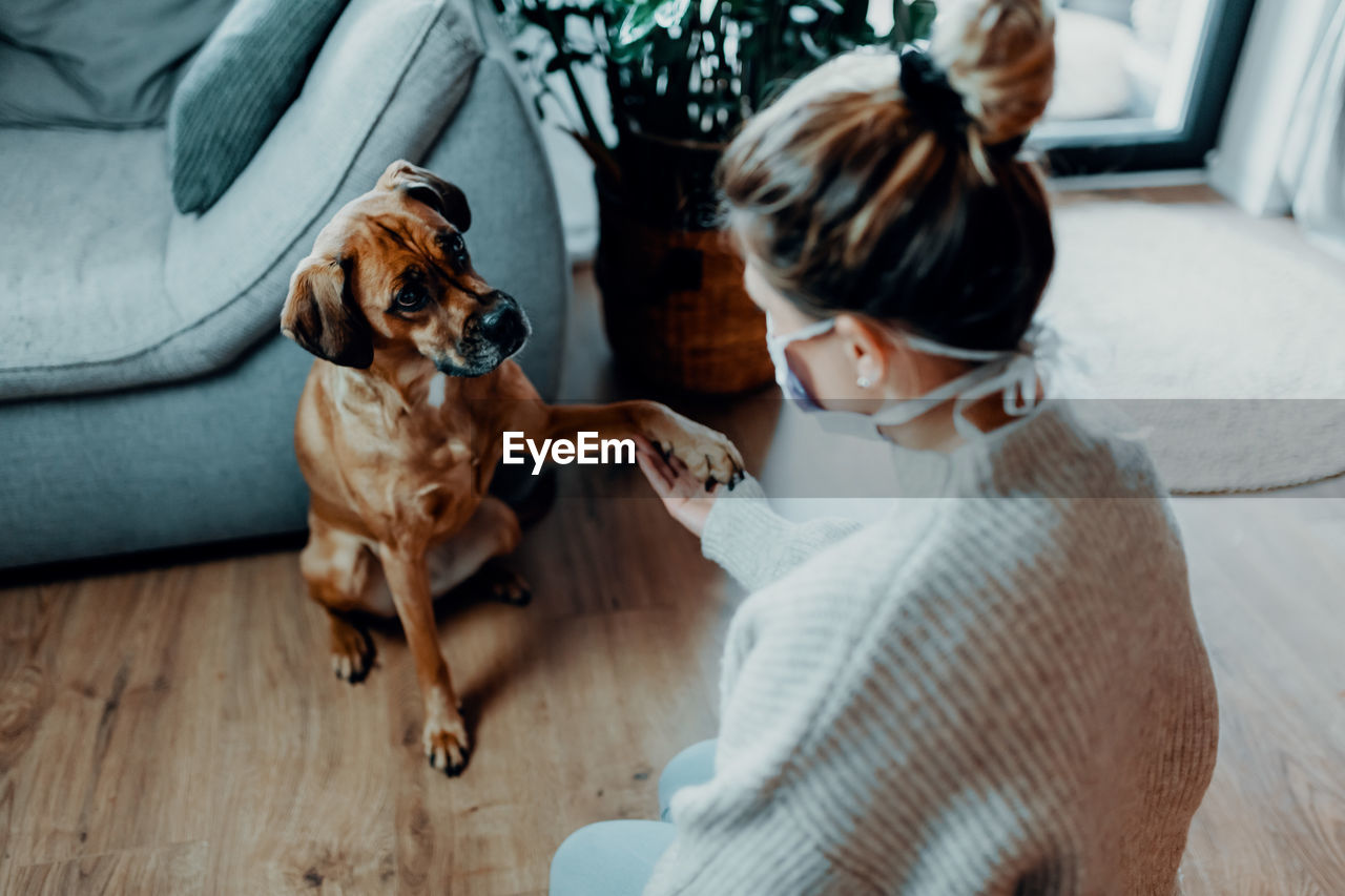 Woman with dog on floor at home