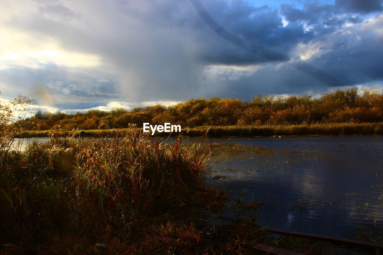 SCENIC VIEW OF LAKE AGAINST CLOUDY SKY