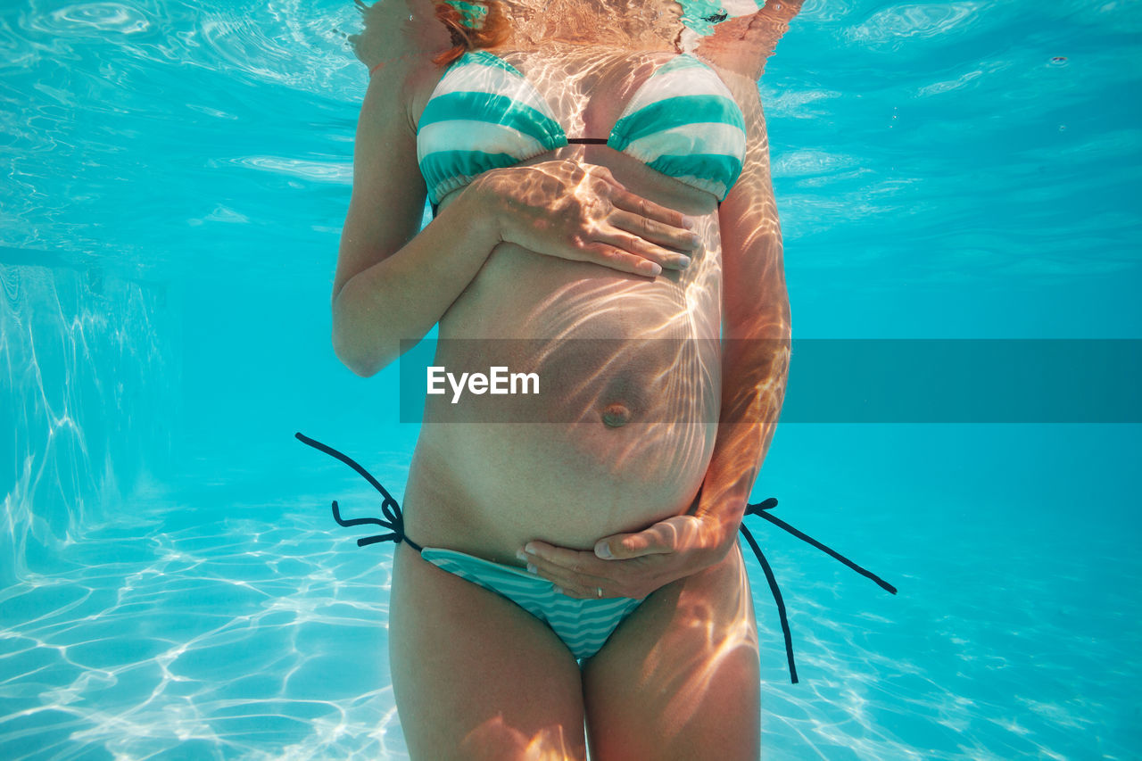Rear view of woman swimming in sea