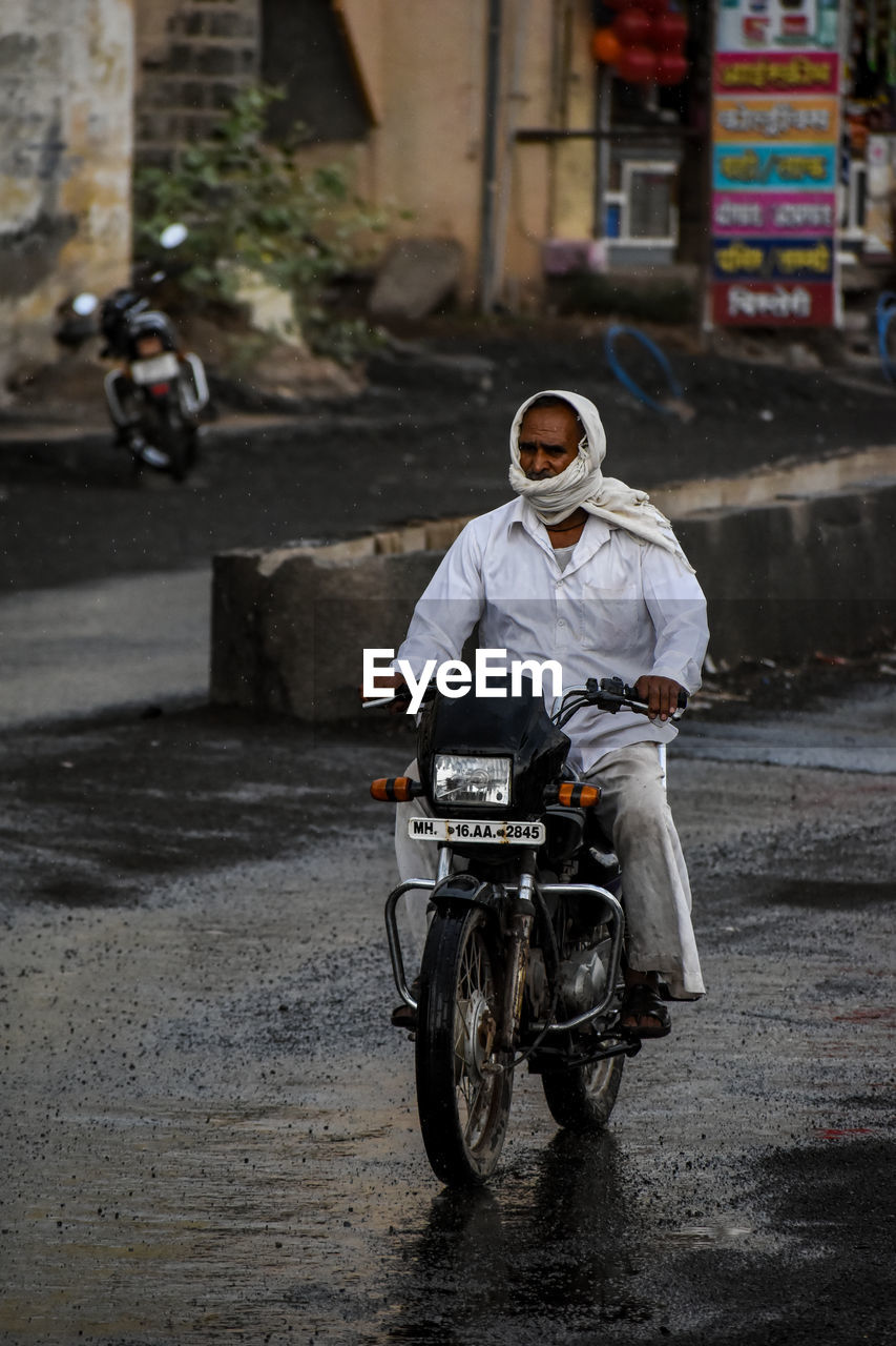 WOMAN RIDING MOTORCYCLE ON STREET