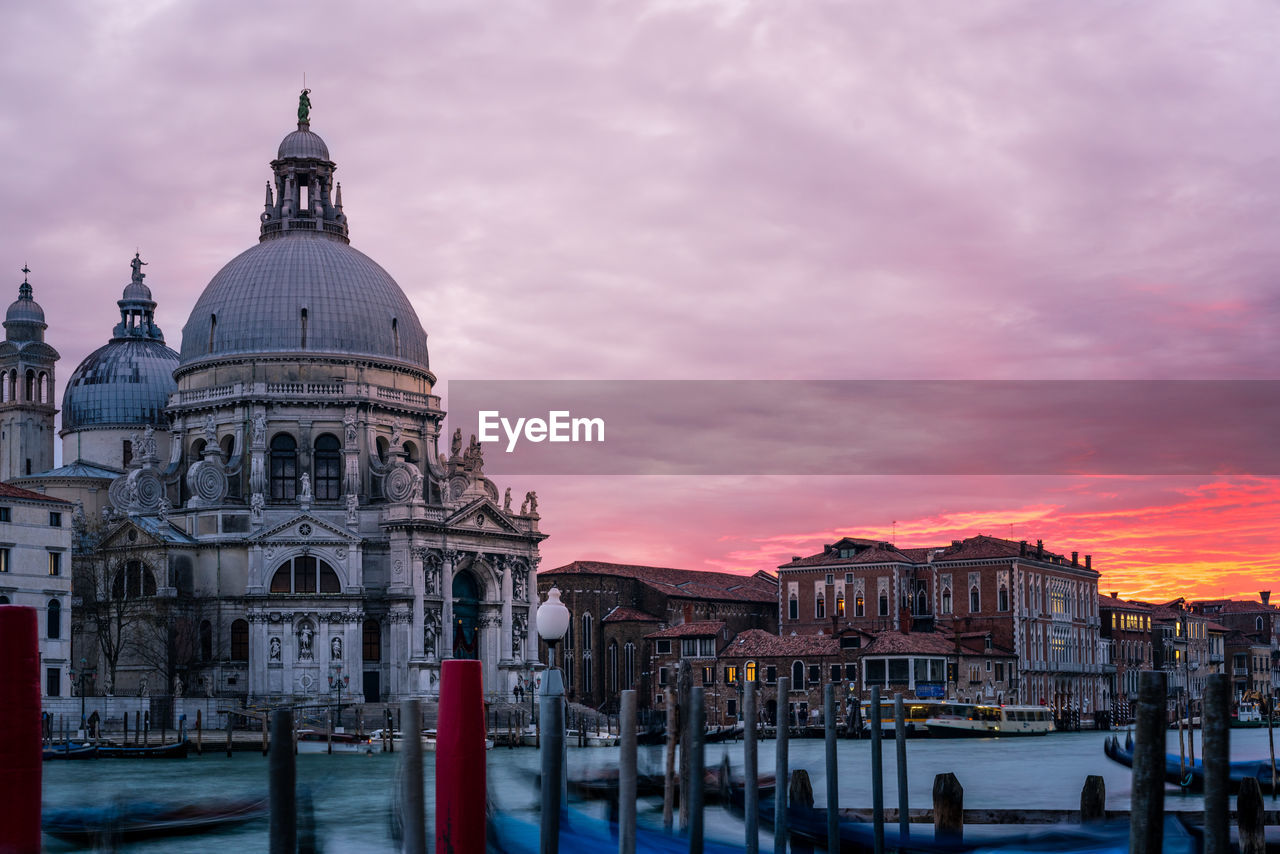 View of cathedral against cloudy sky in city during sunset