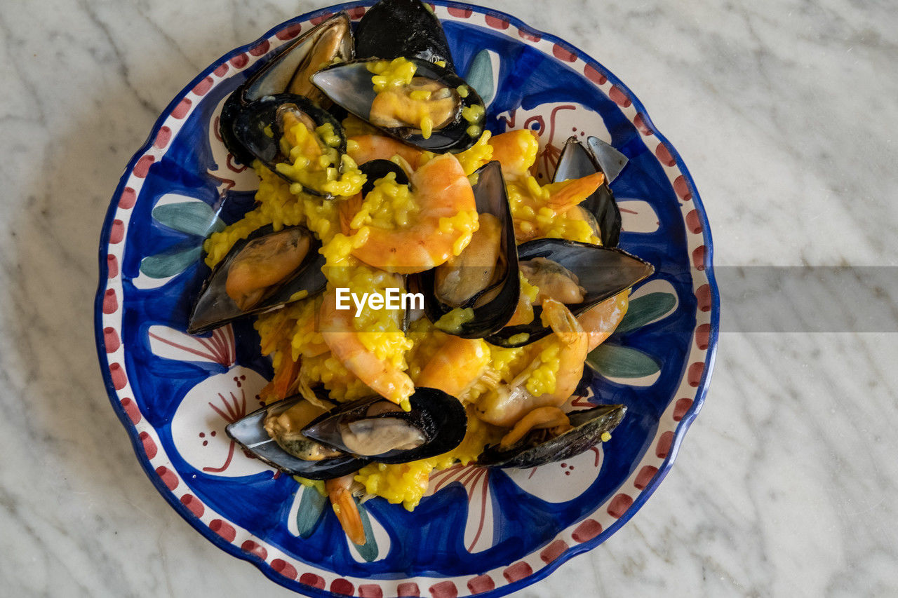 food, food and drink, freshness, dish, healthy eating, wellbeing, mussel, plate, yellow, produce, high angle view, no people, vegetable, directly above, meal, table, indoors, cuisine, seafood, fruit, bowl
