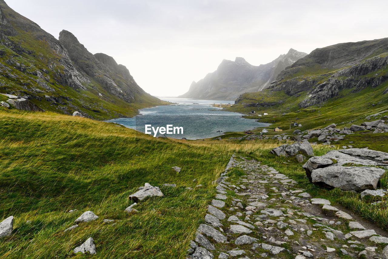 Scenic view of hiking trail leading to remote village vinstad at the coast in lofoten norway