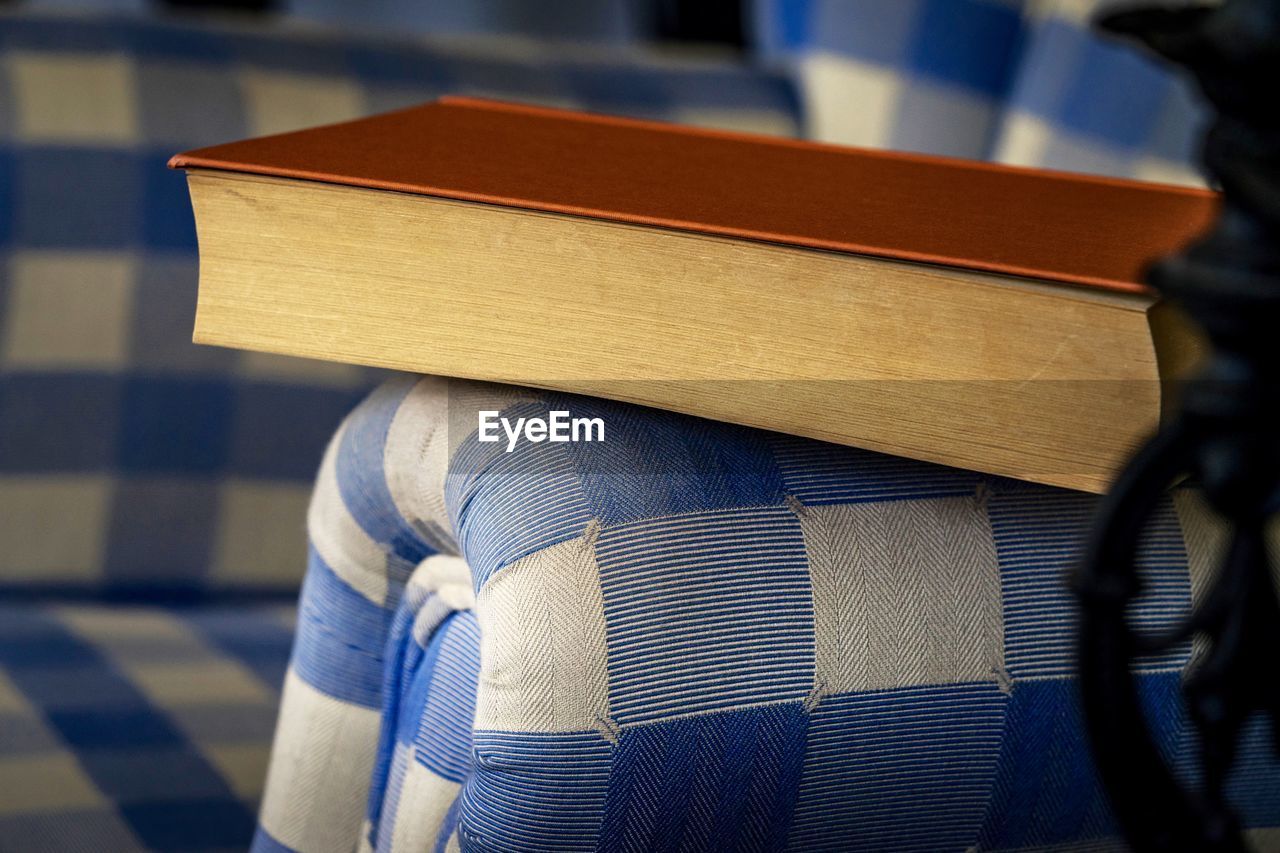 Close-up of book on armchair