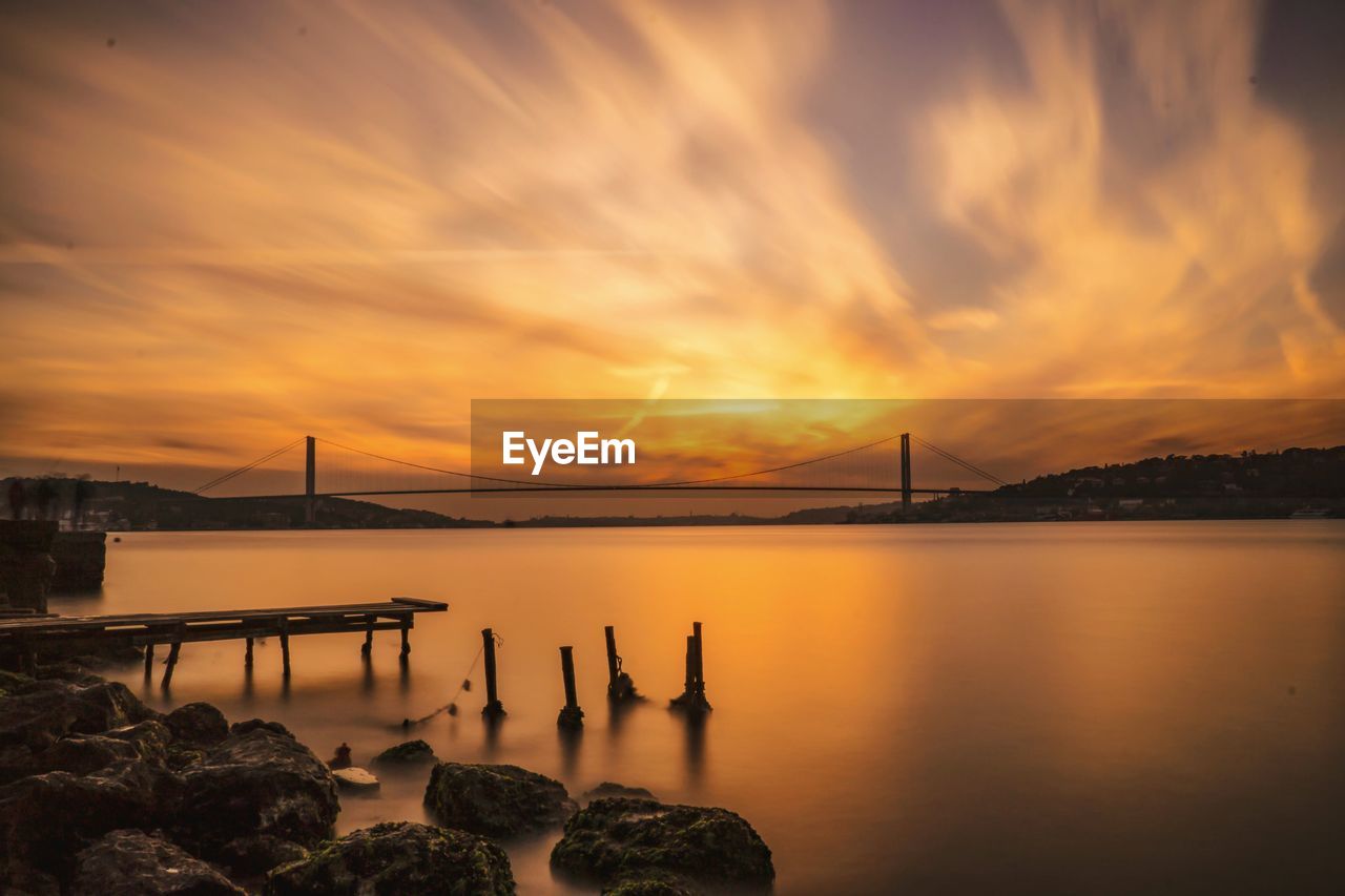 View of bridge over river against cloudy sky