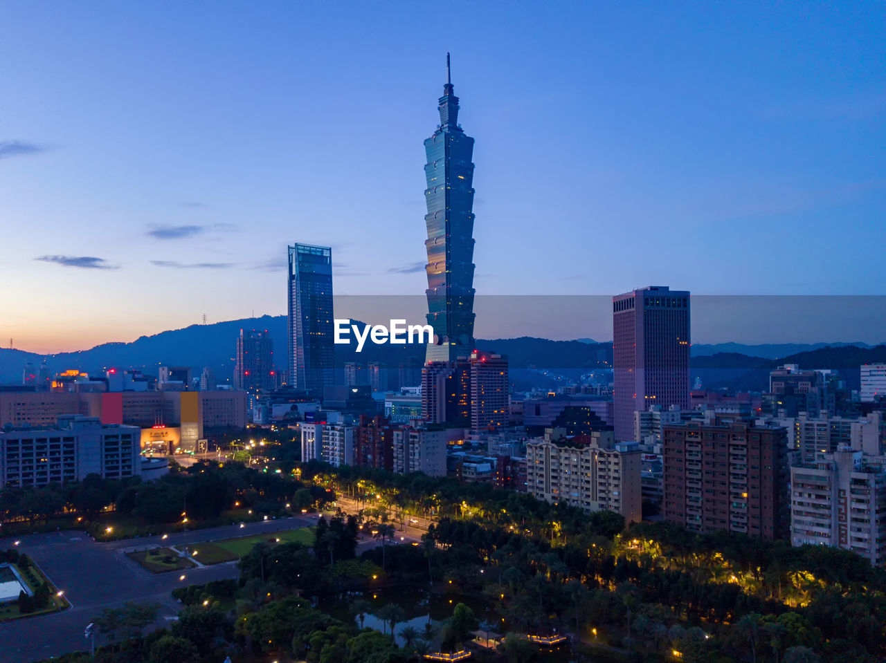 Illuminated buildings in city against sky