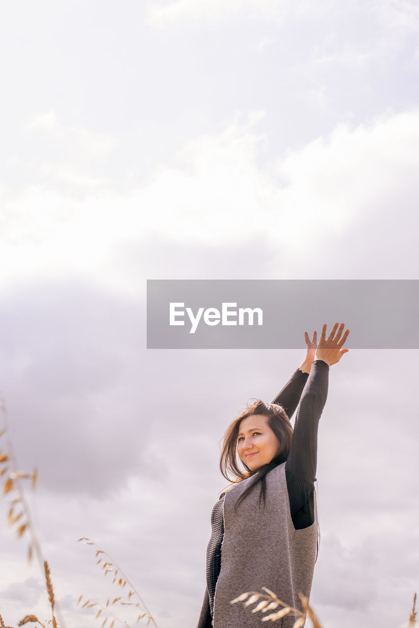 Low angle view of woman standing against sky