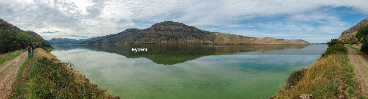 PANORAMIC VIEW OF LAKE AMIDST MOUNTAINS AGAINST SKY