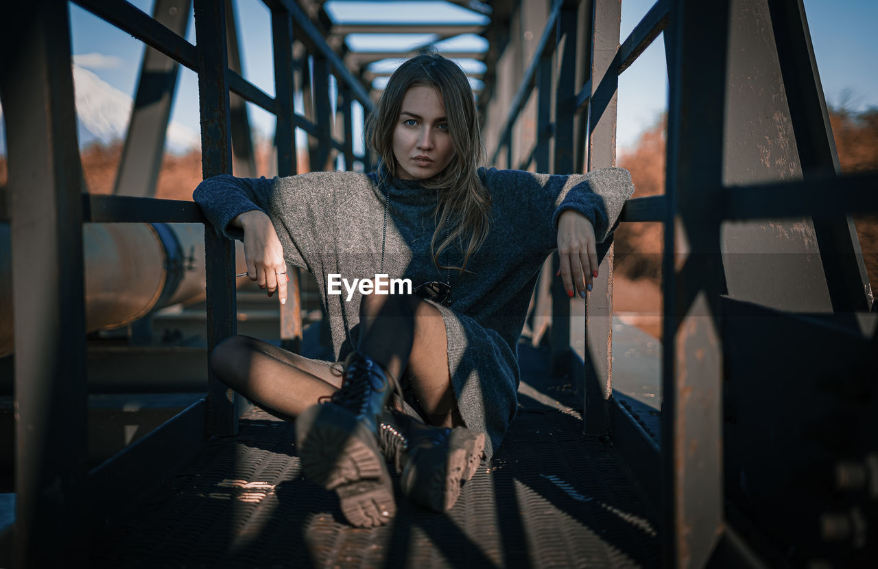 Full length of young woman sitting outdoors