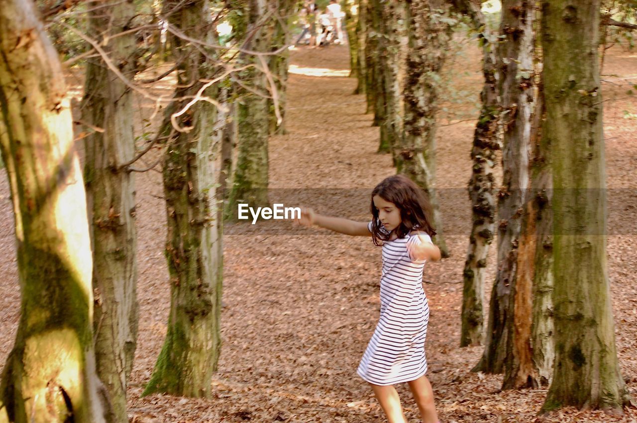 Full length of girl walking in forest