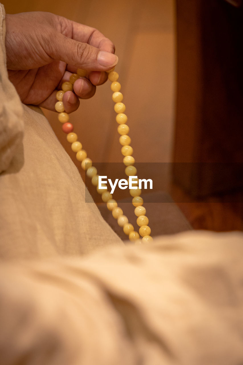 hand, senior adult, indoors, one person, adult, close-up, person, holding, limb, selective focus, yellow, temple, men, seniors