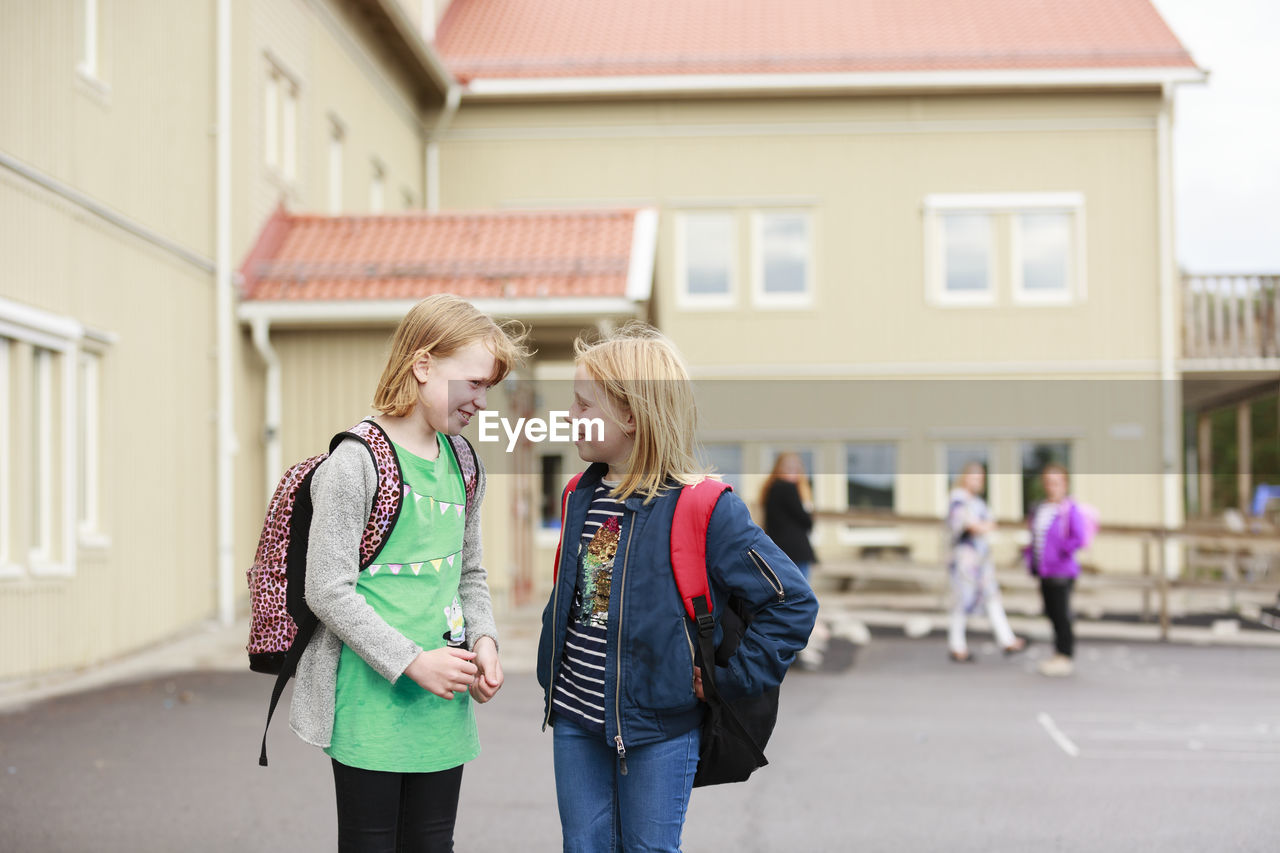 Smiling girls in front of school building