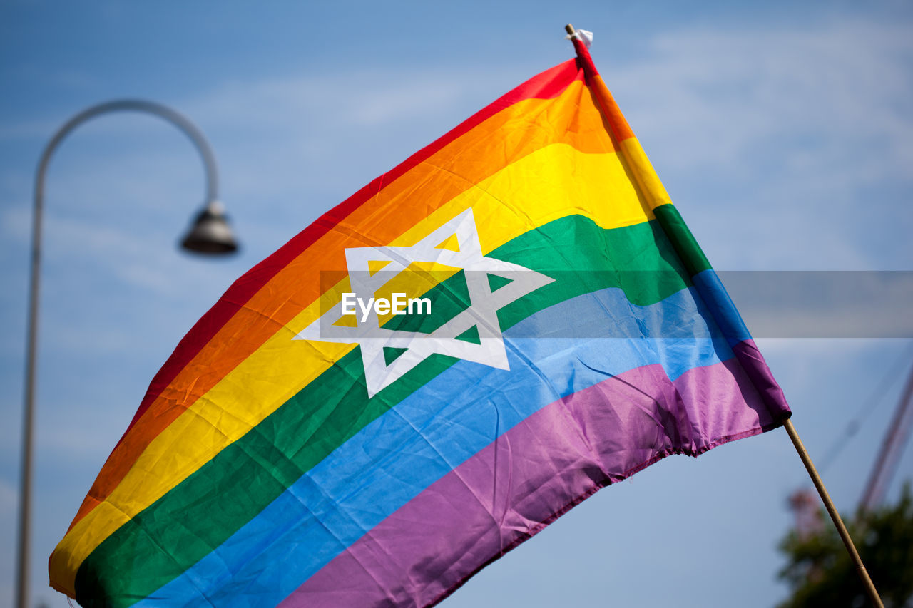 Low angle view of rainbow flag against sky