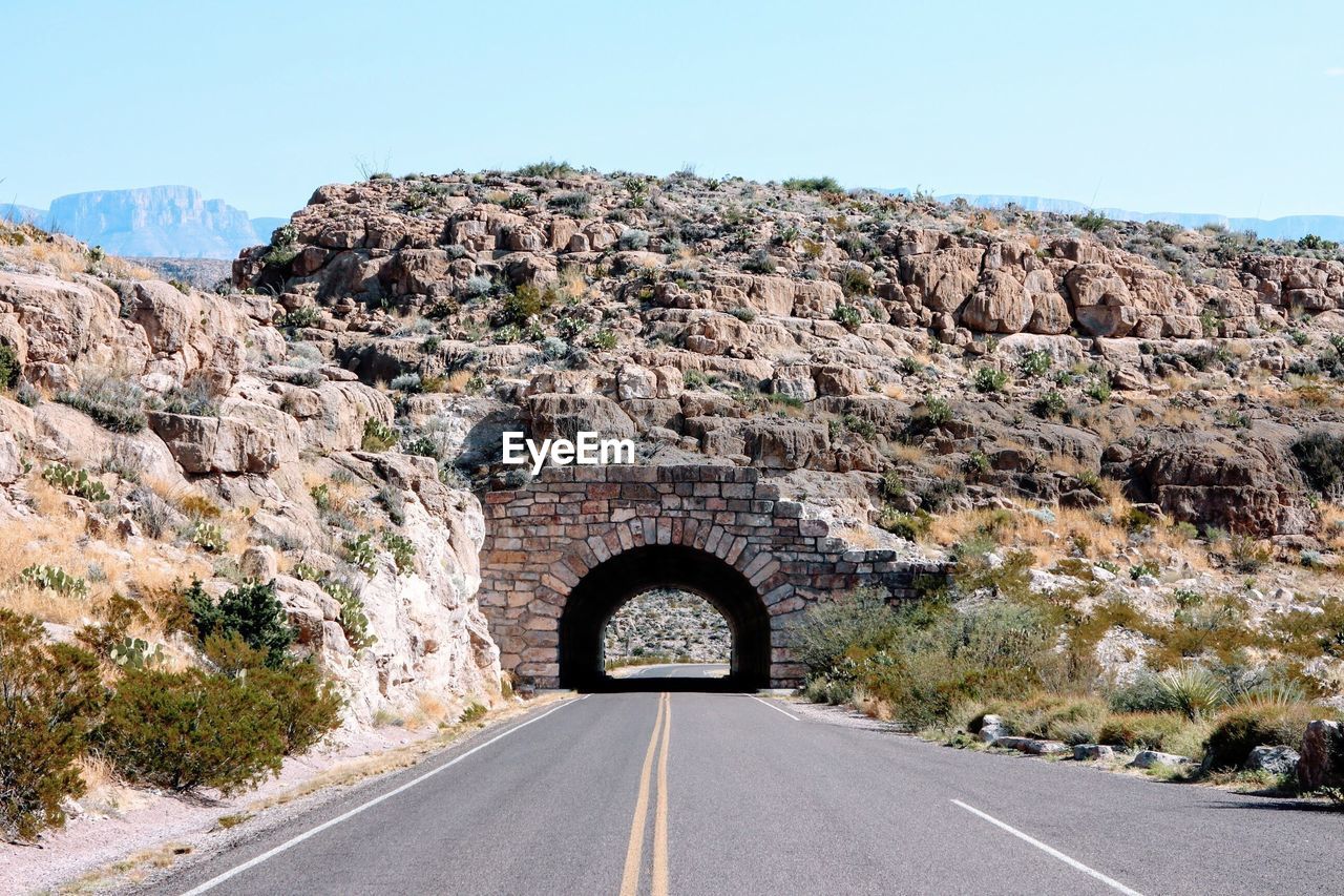 Empty road leading towards archway at big bend national park