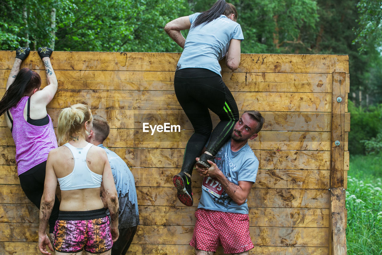 FULL LENGTH OF FRIENDS STANDING ON WOOD