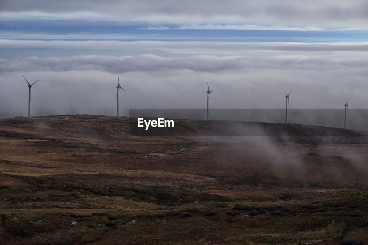 VIEW OF WIND TURBINE AGAINST CLOUDY SKY