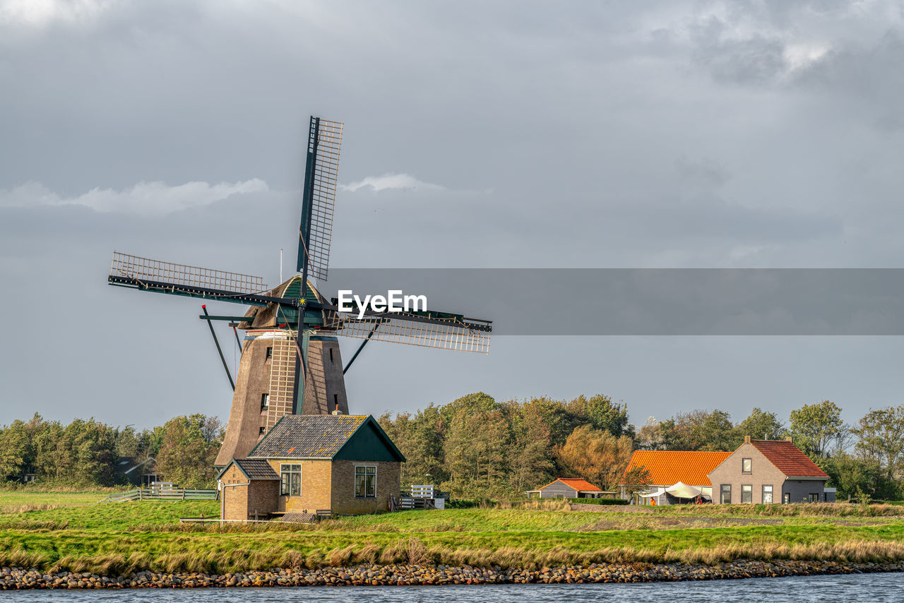 Traditional windmill on field against sky