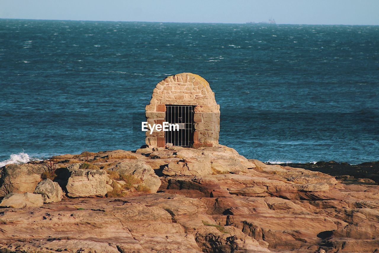 SCENIC VIEW OF SEA AGAINST ROCK FORMATION