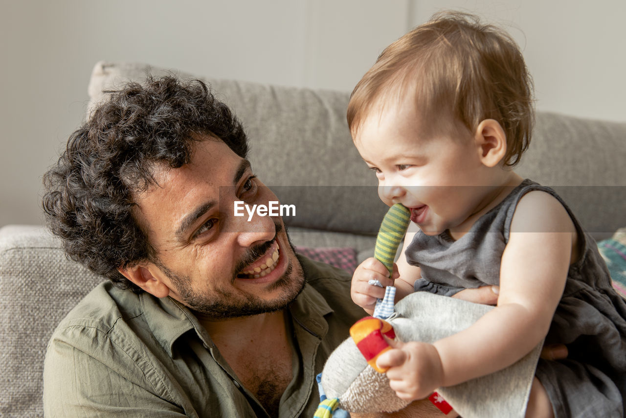 Father having some fun and playing her baby girl daughter at hom