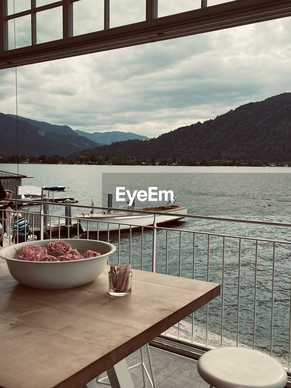 CHAIRS AND TABLE BY SEA AGAINST MOUNTAINS