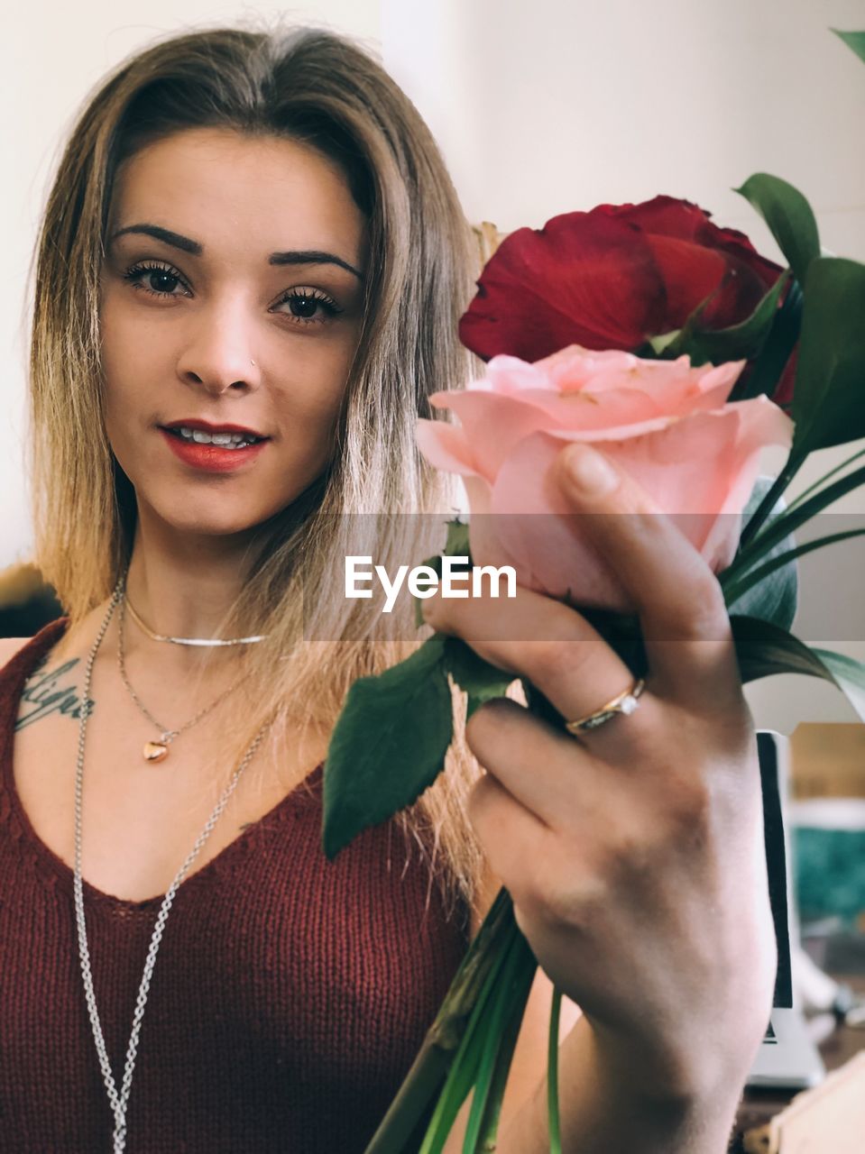 PORTRAIT OF A BEAUTIFUL YOUNG WOMAN HOLDING ROSE