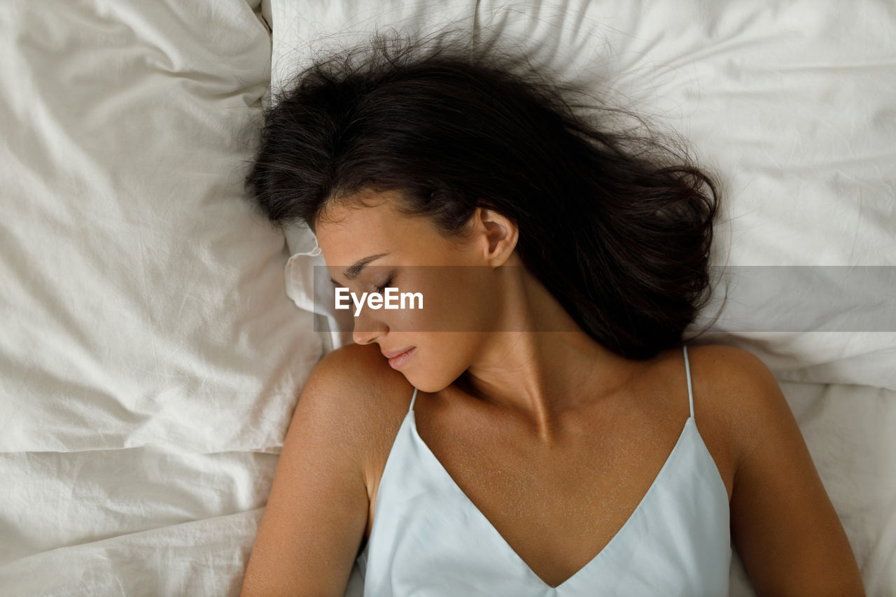 close-up of young woman lying on bed