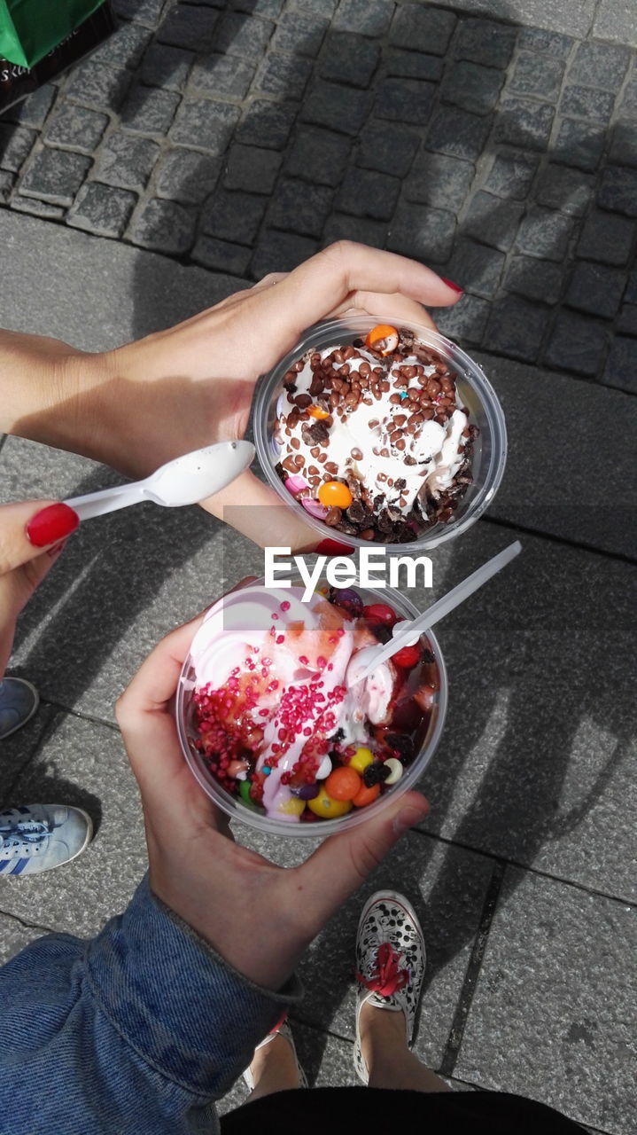 HIGH ANGLE VIEW OF WOMAN HOLDING ICE CREAM IN GLASS