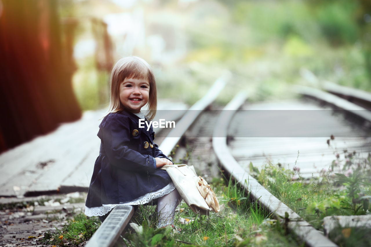 Portrait of happy girl sitting outdoors