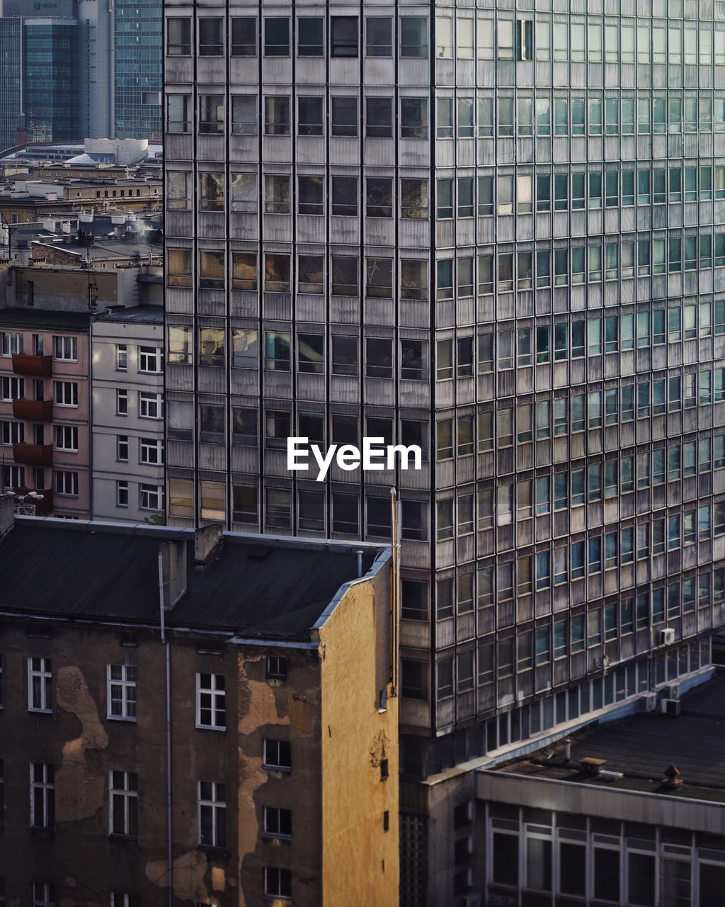 Urban view of obscure residential buildings and midernist high rise