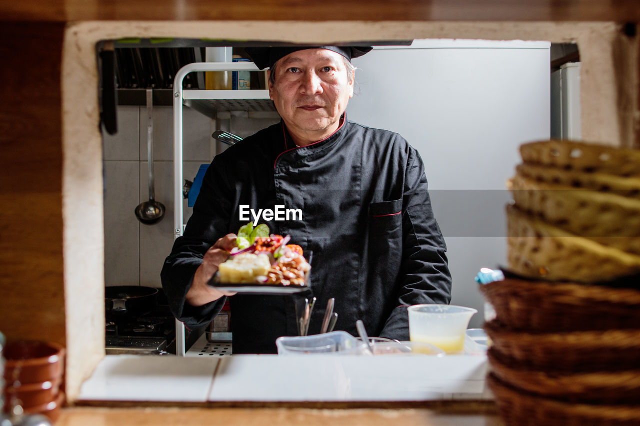 Portrait of chef preparing food in kitchen