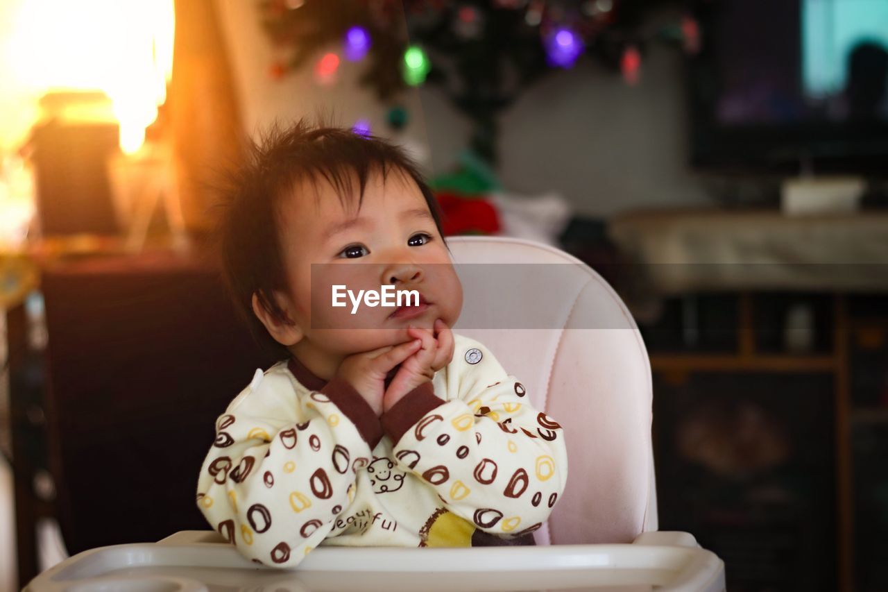 Portrait of cute baby girl sitting at home