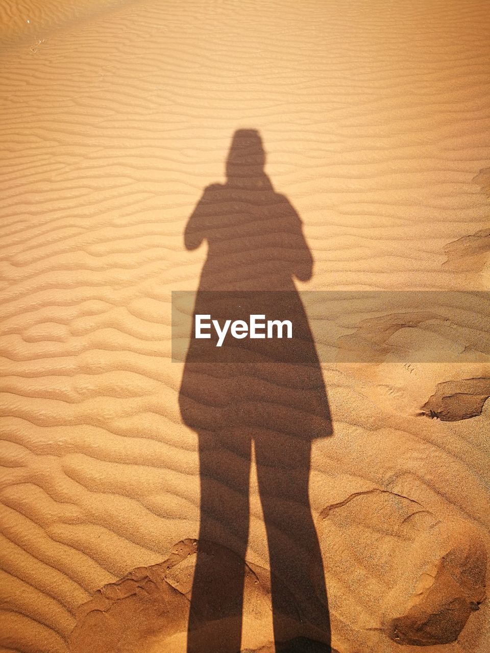 Shadow of woman on sand dune in desert