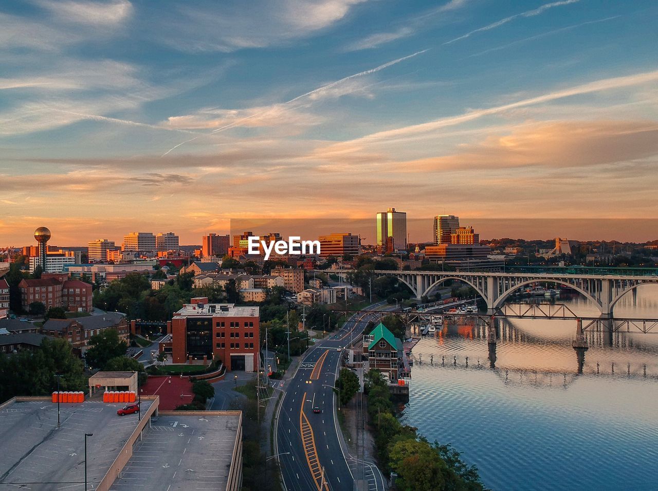 CITY BY BUILDINGS AGAINST SKY AT SUNSET