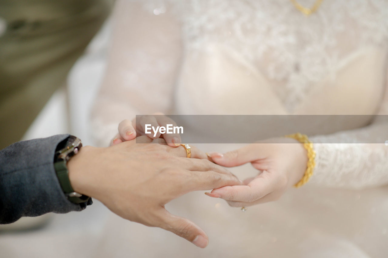 Midsection of bride holding hands