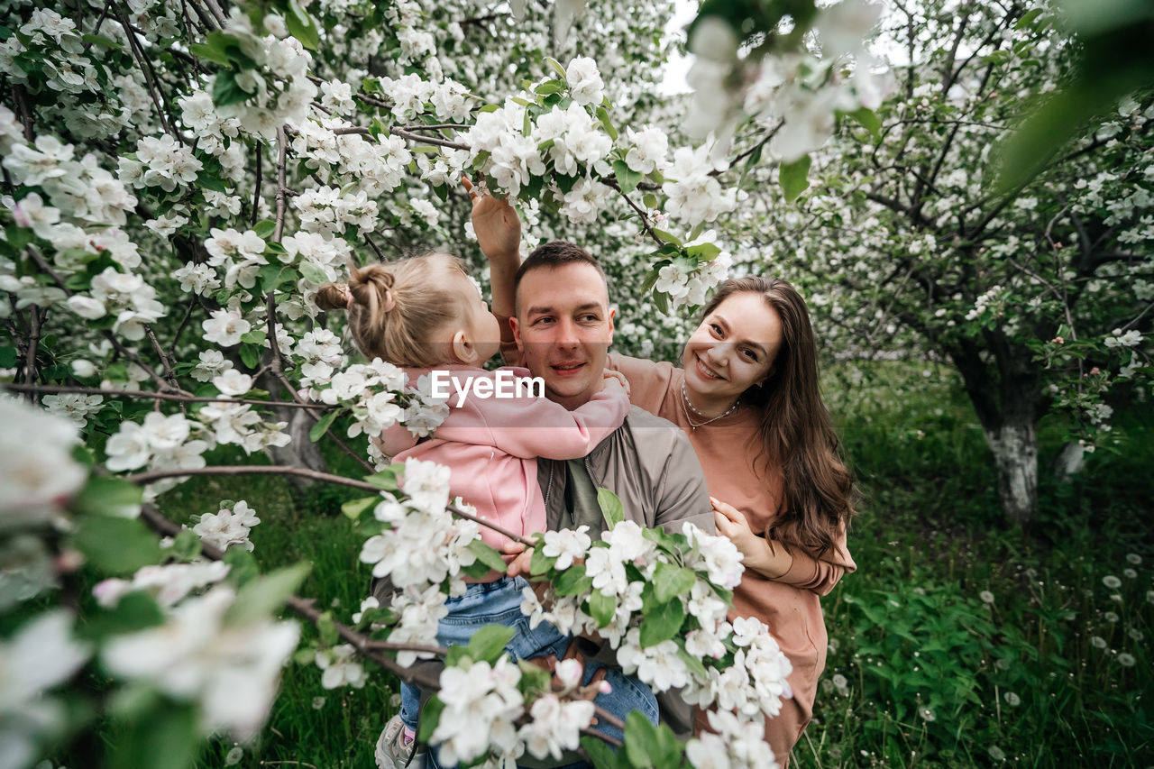 Family mom mom baby daughter in the garden blooming apple trees