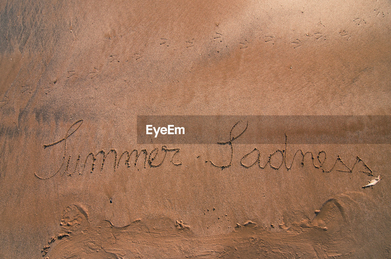 High angle view of text on sand at beach