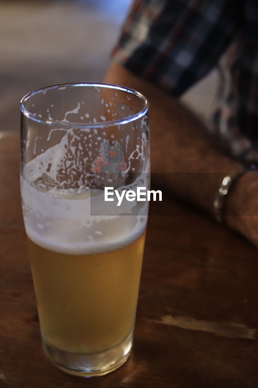 CLOSE-UP OF BEER GLASSES ON TABLE