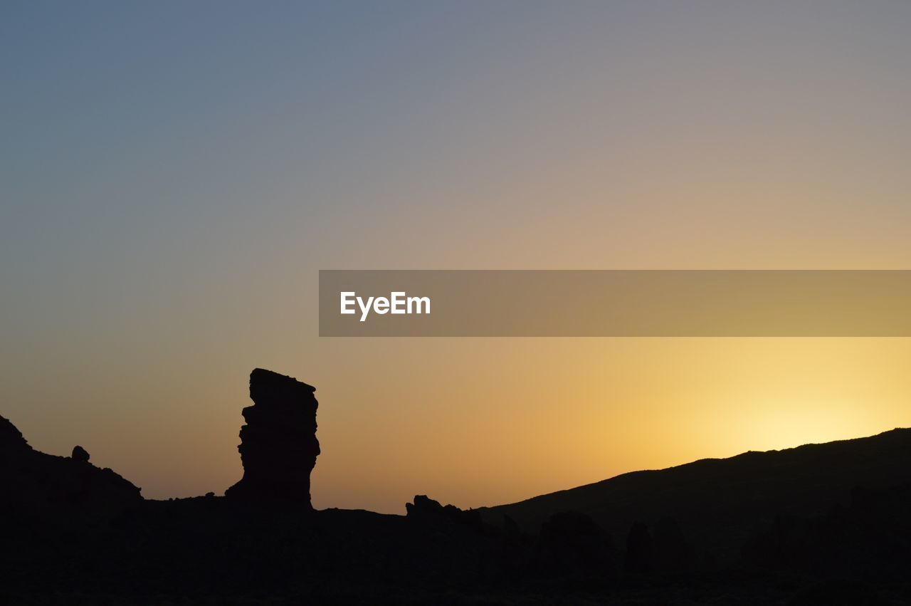 SCENIC VIEW OF SILHOUETTE LANDSCAPE AGAINST SKY AT SUNSET