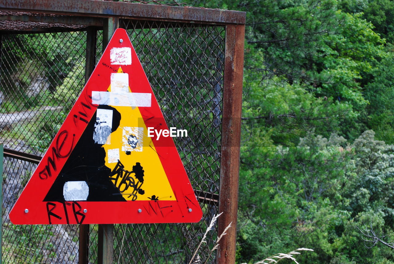 CLOSE-UP OF ROAD SIGN ON TREE