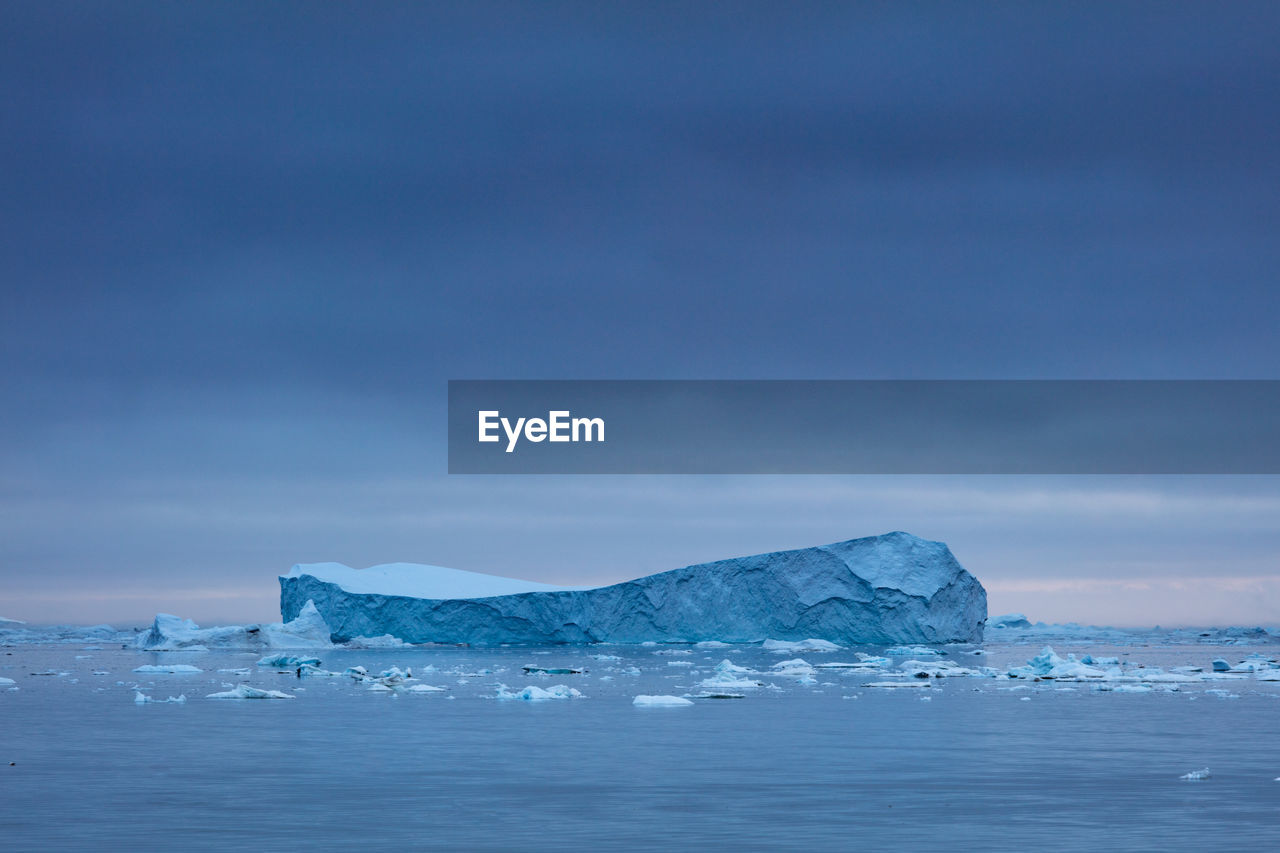 Icebergs in sea against sky