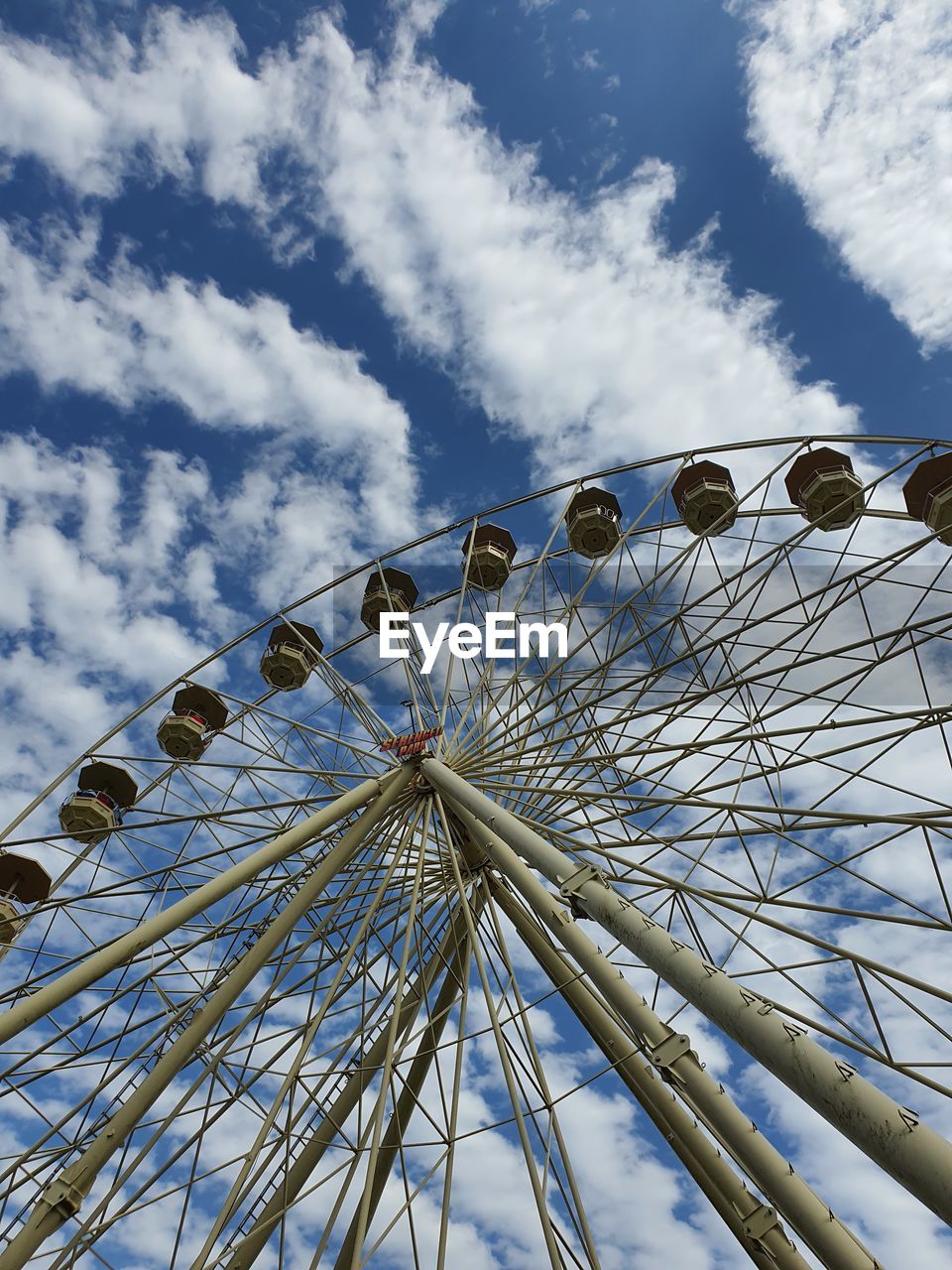 LOW ANGLE VIEW OF FERRIS WHEEL AGAINST CLOUDY SKY