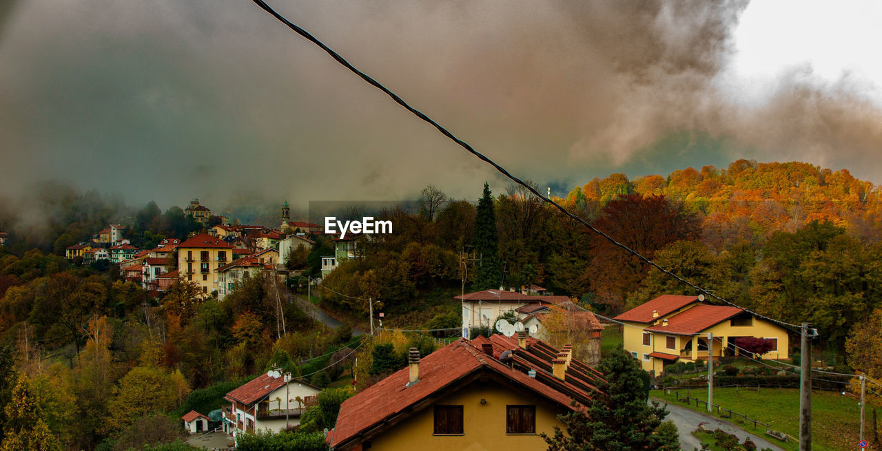 HOUSES AND TREES AGAINST SKY IN CITY