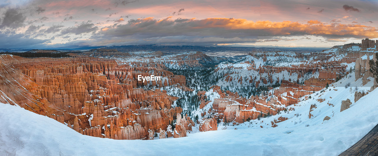 SNOW COVERED LANDSCAPE AGAINST SKY DURING SUNSET