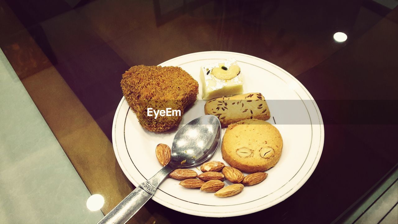 High angle view of cookies with almond and cutlet in plate